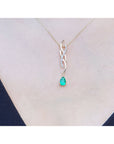 Pear-shaped emerald pendant on a twisted 14K yellow gold slider necklace with diamond accents, shown worn on a person's neck.