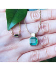 Asscher cut 2.64 ct. Colombian Emerald necklace with princess cut diamond on 18K yellow gold chain.
