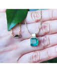 Asscher cut 2.64 ct. Colombian Emerald necklace with princess cut diamond on 18K yellow gold chain.