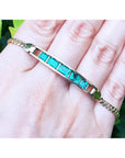 14K yellow gold bracelet with five emerald-cut Colombian emeralds on a woman's hand.