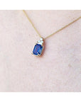 14k gold necklace with a rectangular blue sapphire pendant and three accent diamonds.
