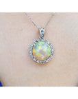 Ethiopian Welo opal and diamond pendant in 14K white gold, featuring a round opal with red flashes.