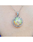 Ethiopian Welo opal and diamond pendant in 14K white gold, featuring a round opal with red flashes.