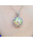 Ethiopian Welo opal and diamond pendant in 14K white gold, featuring a round opal with red flashes.