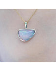 Opal pendant necklace on a person's neck with a plain background