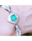 18K white gold emerald and pearl bracelet with a bezel-set green emerald, diamonds, and two strands of pearls.