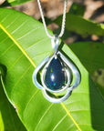Teardrop 4.30 ct Ethiopian black opal pendant in sterling silver with multicolor flashes on a green leaf.