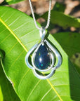 Teardrop 4.30 ct Ethiopian black opal pendant in sterling silver with multicolor flashes on a green leaf.