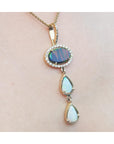 Opal pendant necklace on a person's neck with a plain skin background.