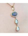 Opal pendant necklace on a person's neck with a plain skin background.