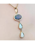 Black and white Australian opal pendant with an oval black opal, two teardrop white opals, and diamond accents on a 14K gold chain.