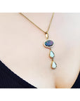 Black and white Australian opal pendant with two teardrop opals, set in 14K yellow gold on a delicate chain.