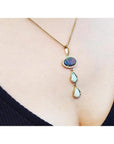 Black and white Australian opal pendant with two teardrop opals, set in 14K yellow gold on a delicate chain.