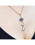 Black and white Australian opal pendant with two teardrop opals, set in 14K yellow gold on a delicate chain.
