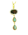 The topside view of an opal pendant necklace with gold setting on a white background.