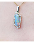 Opal pendant necklace on a pink background