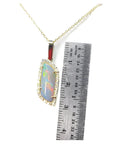 14K yellow gold pendant necklace with a colorful opal and diamond halo, next to a ruler.