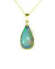 Ethiopian opal pear-shaped pendant with blue/violet play-of-color, set in 14K yellow gold.
