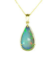 Ethiopian opal pear-shaped pendant with blue/violet play-of-color, set in 14K yellow gold.