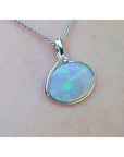 Opal pendant necklace on a person's neck with a white background