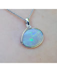 2.25 ct Australian opal pendant in 14K white gold, east-west bezel set with bluish-green flashes.