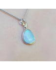Freeform bluish-green Australian opal pendant, bezel set in 14K white gold on a chain.