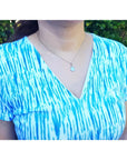 Bluish-green Australian opal pendant, freeform, bezel set in 14K white gold, worn on a silver chain.