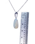 Necklace with an opal pendant next to a ruler on a white background