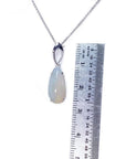 Pear-shaped 2.12 ct white opal solitaire pendant in 14K white gold, shown with a ruler.