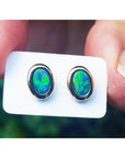 Oval blue-green Australian opal doublet stud earrings in 14k yellow gold, bezel set.