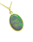 Oval Australian opal pendant with green-bluish rainbow play, set in 14K yellow gold.
