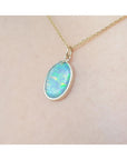 Opal pendant necklace on a beige skin background