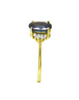 14K yellow gold ring with a prominent oval blue sapphire and two small diamonds on each side.