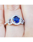 14k white gold ring with a natural blue sapphire oval cut halo diamond on a finger