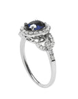 1.08 ct oval blue sapphire ring in 14K white gold with diamond halo and accents.