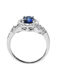 1.08 ct oval blue sapphire ring in 14K white gold with diamond halo and pavé band.