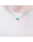 Oval 1.00 ct. emerald necklace with diamond halo, east-west, on a 14K white gold chain.