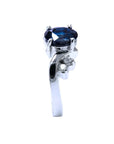 14K white gold ring with a 1.43 ct oval deep blue sapphire and accent diamonds.