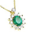 A 14k yellow gold necklace with a oval cut emerald gemstone in a halo diamond prong set.