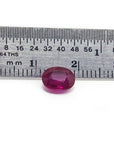 1.59 carat natural Burma ruby, oval cut, medium deep red, displayed next to a ruler.