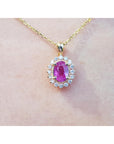 Gold necklace with a pink oval cut natural sapphire pendant on a skin background