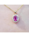 1.25 ct. oval pink sapphire halo diamond pendant on a 14K yellow gold chain.