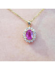 1.25 ct. oval pink sapphire halo diamond pendant on a 14K yellow gold chain.