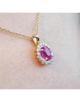 Oval pink sapphire halo diamond necklace pendant in 14K yellow gold.