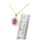 14K yellow gold necklace with oval pink sapphire halo diamond pendant, next to a ruler.