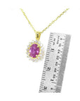 14K yellow gold necklace with oval pink sapphire halo diamond pendant, next to a ruler.