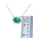 1.00 ct oval emerald necklace with diamond halo, 14K white gold chain, shown with ruler.