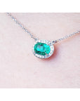 Colombian oval cut emerald necklace east west orientation halo natural diamonds prong set crafted in 14k white gold