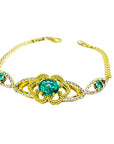 Gold bracelet with natural emeralds gemstones on a white background.