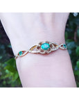 A women's bracelet with an oval cut natural colombian emerald and accent diamonds in 14k gold.